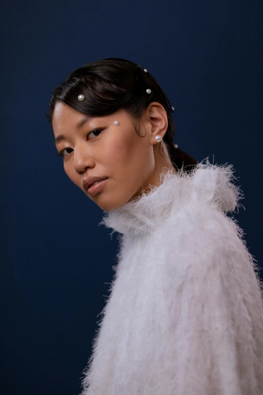 a woman is wearing a pearled headband and dress