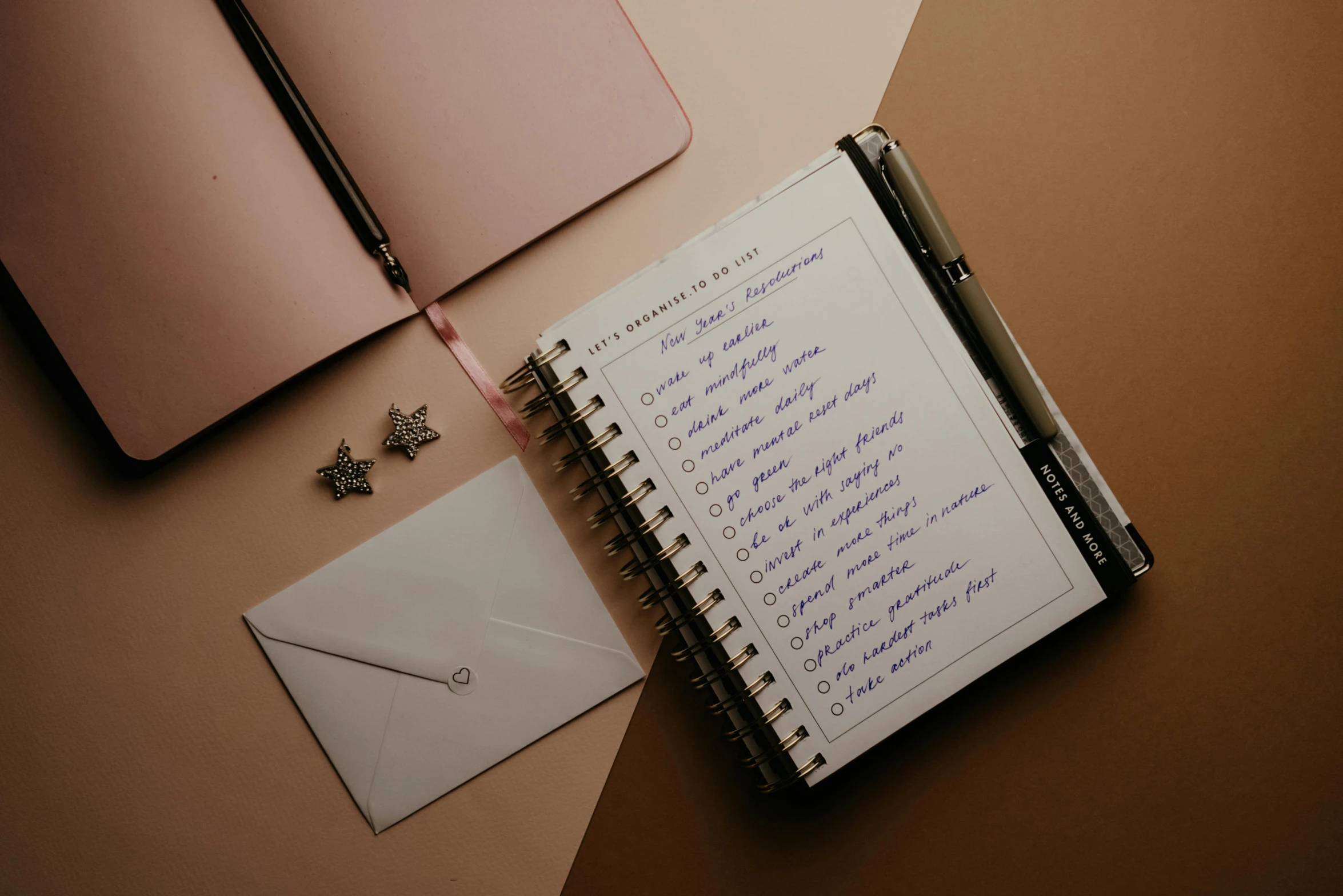 a notebook, pen and notebook with a list on it