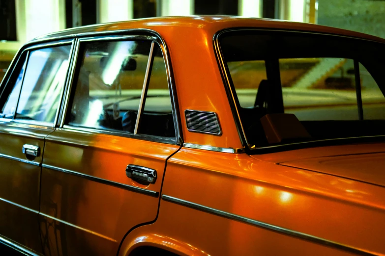 an orange car with an old fashioned grill and window tint