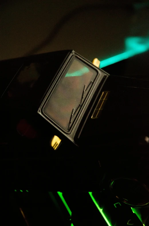 a black and green object with a green light on it