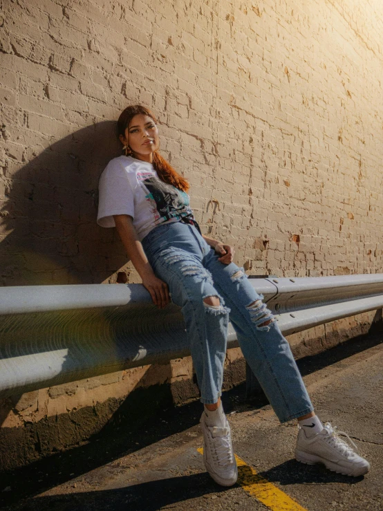 a girl sitting on a rail next to a wall