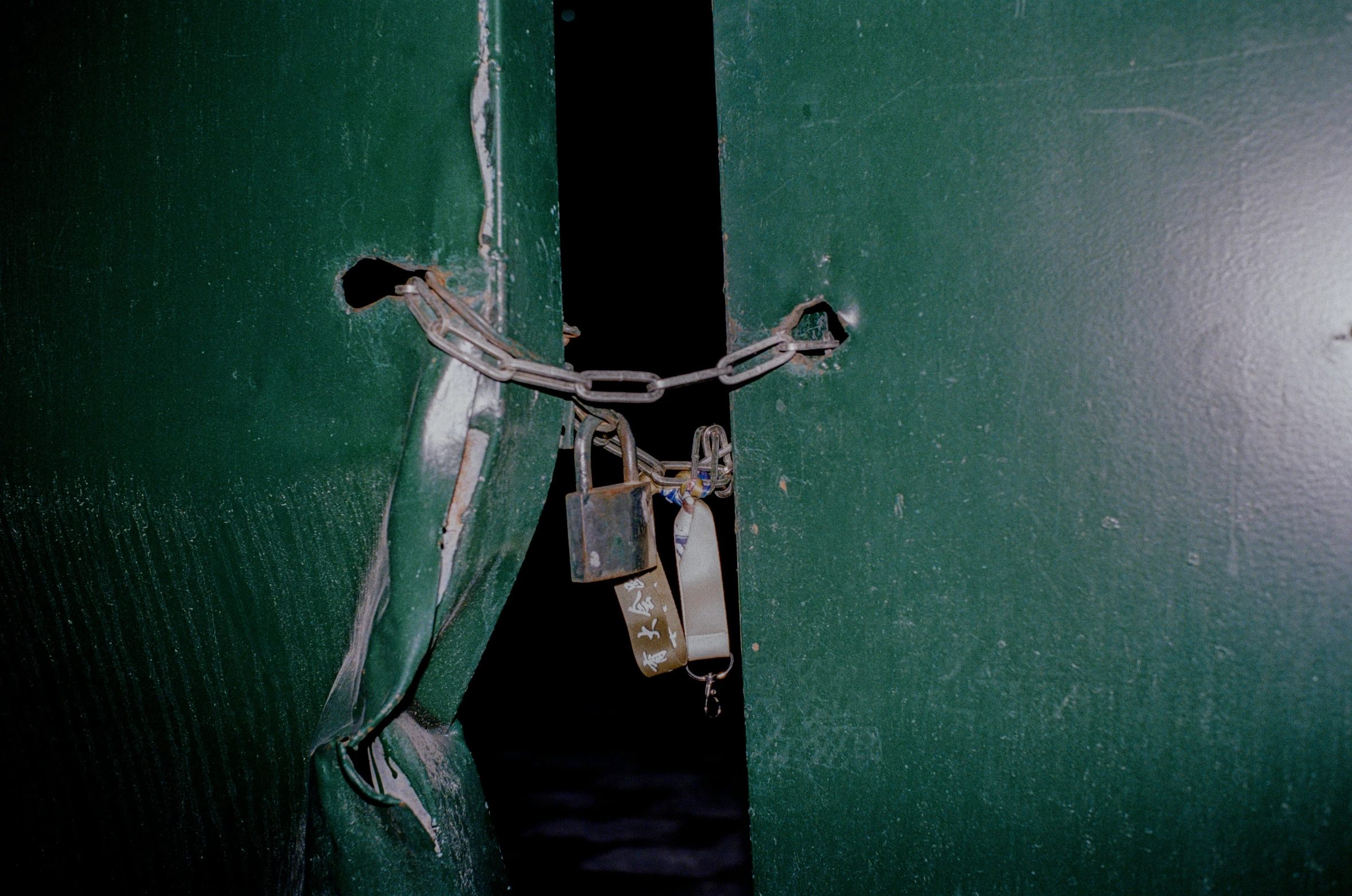 there is a broken lock on the side of a green door