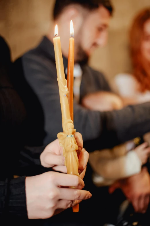 a man and woman are holding candles in their hands