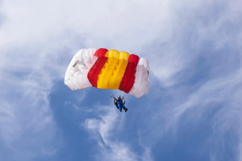 a person is attached to a parachute against the sky