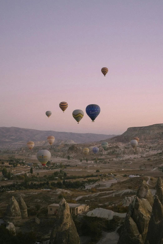  air balloons over a rocky valley in a landscape with mountains