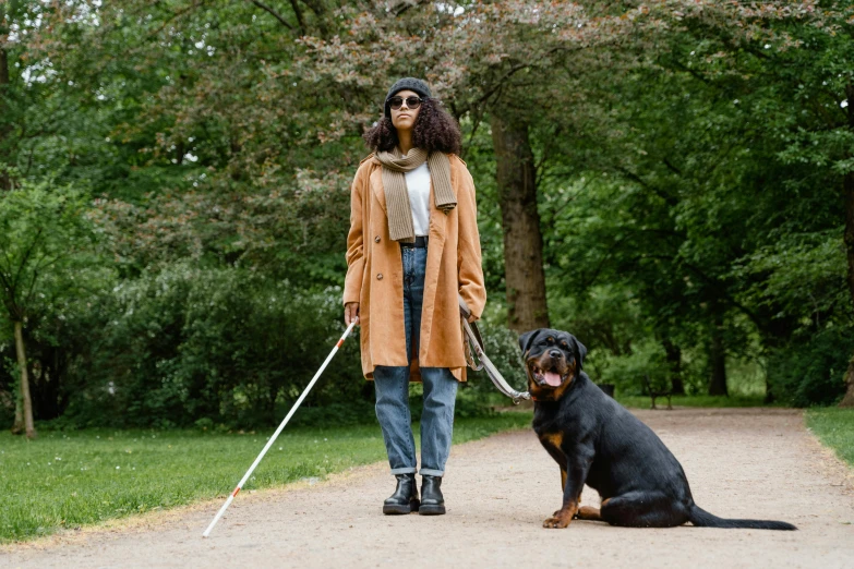 an african american female walking a dog and wearing winter clothing