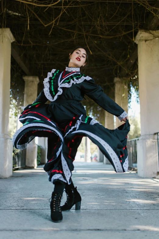 the woman in black and white dress is dancing on the street