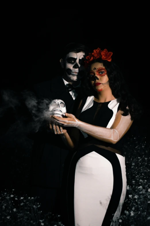 a woman with makeup on her face standing beside a man with a skeleton face painted on his forehead