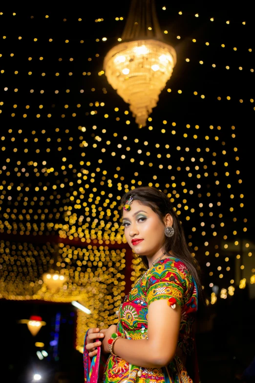 a woman is standing under a light display