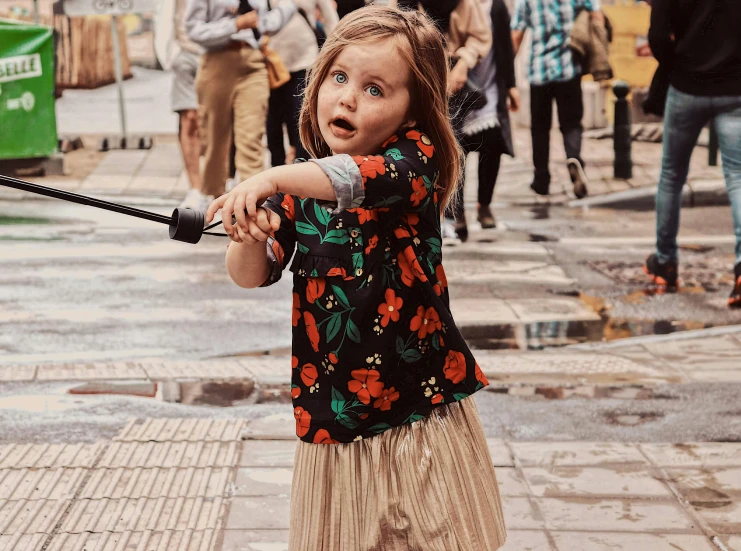 a little girl is holding onto an umbrella