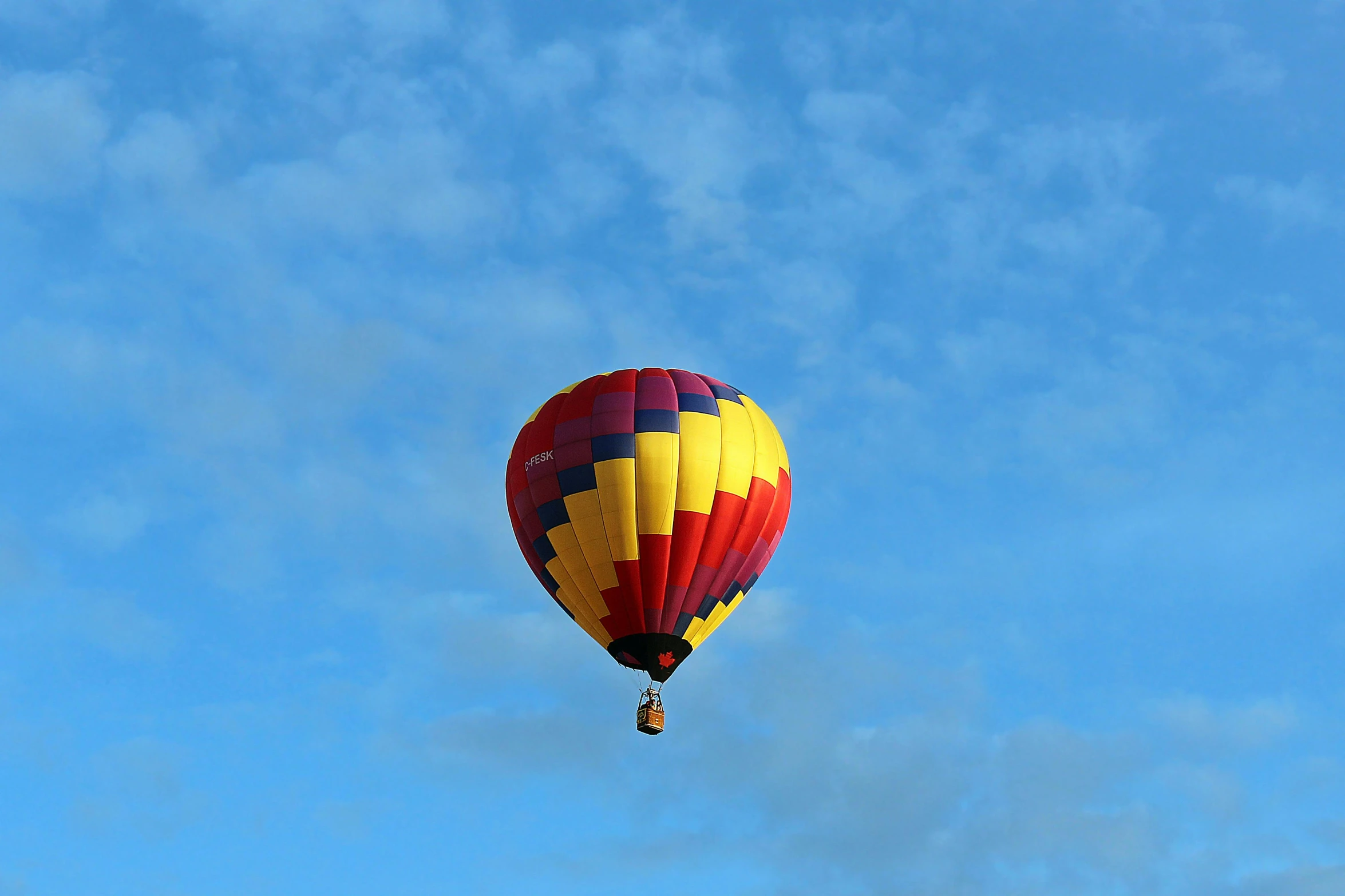 a yellow and red  air balloon in the air