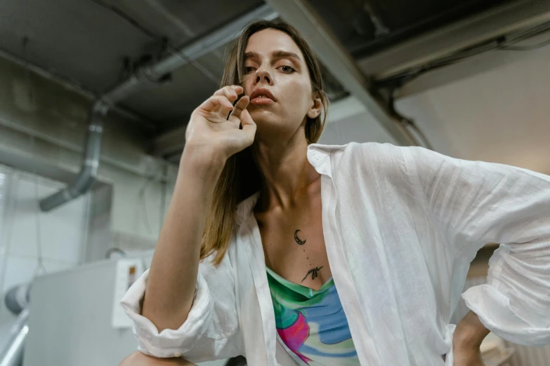 a woman smoking a cigarette wearing a white shirt