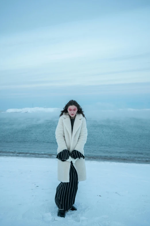 a woman wearing white and black clothes standing in the snow