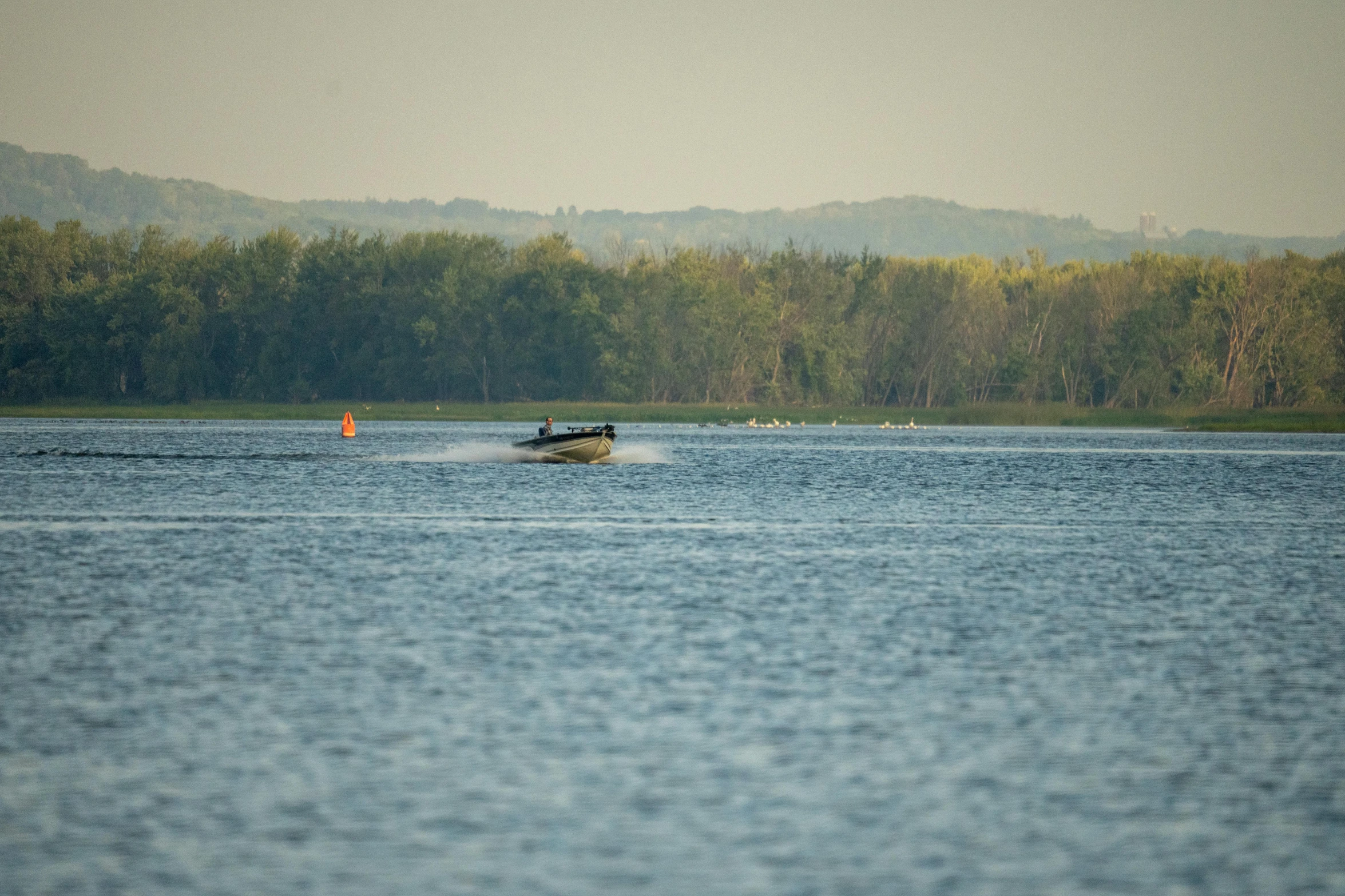 a small motor boat riding through the middle of water