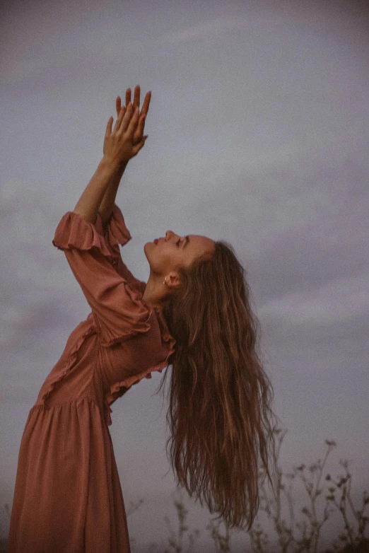 a woman reaches into the air as she reaches her hands up