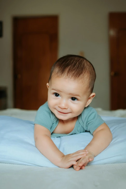 a young baby is laying on his back with his arms folded