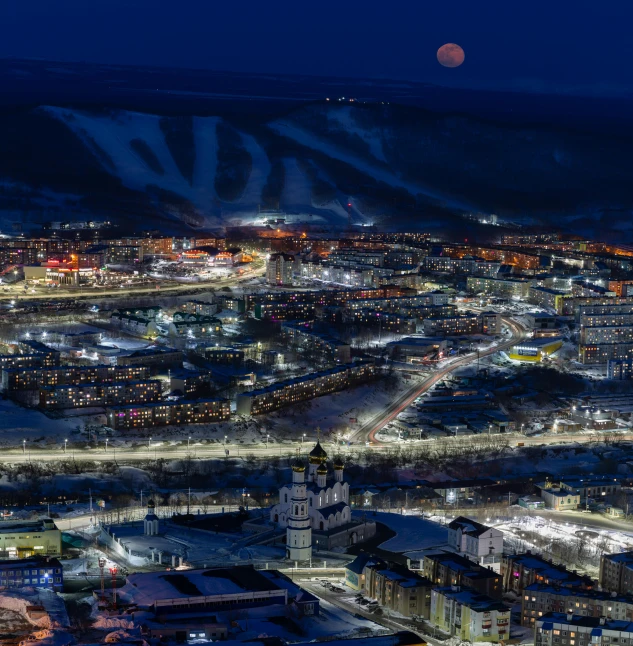 a snowy city with buildings and a night sky