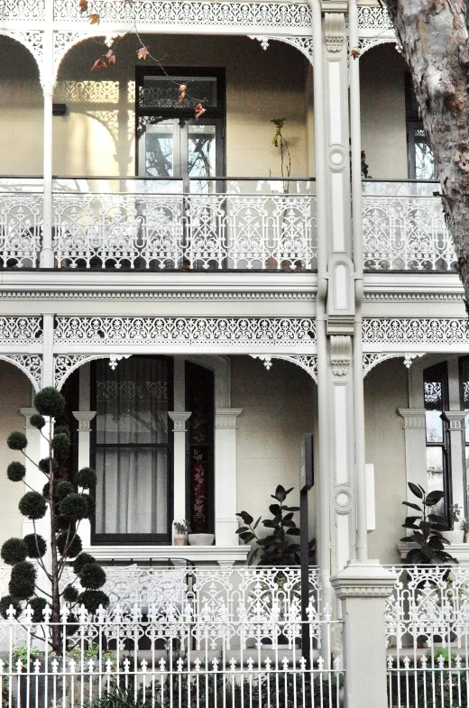 a very tall house with many balconies and white ironwork