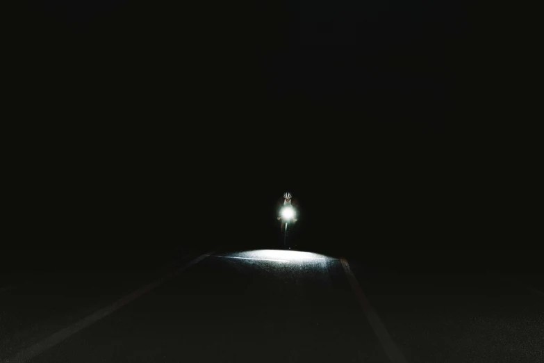 man standing in the middle of road at night