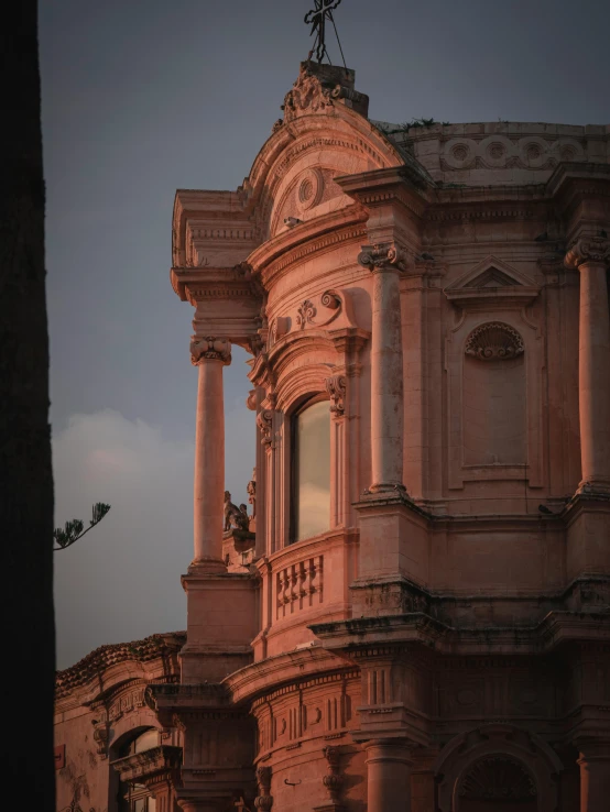 a tall, intricately designed building is illuminated with the glow from the sun