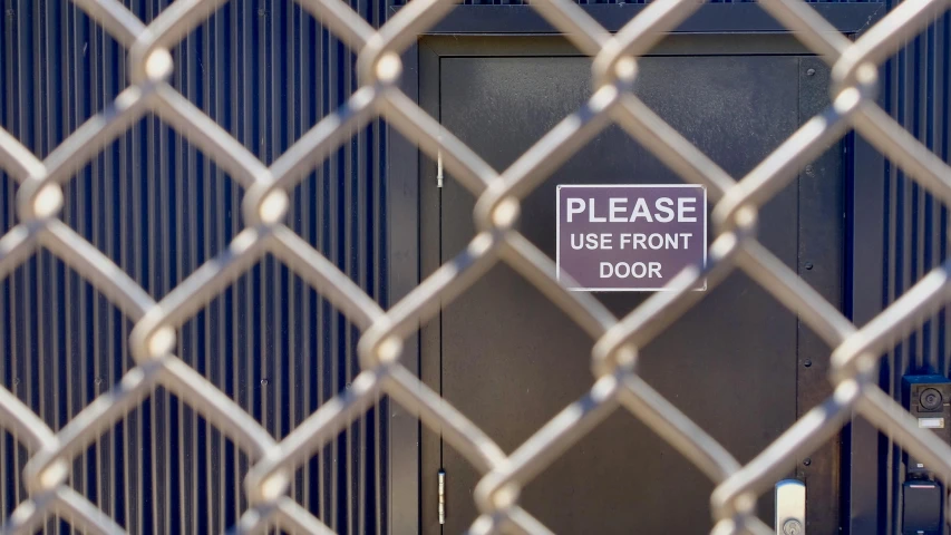 a sign hanging on a chain link fence