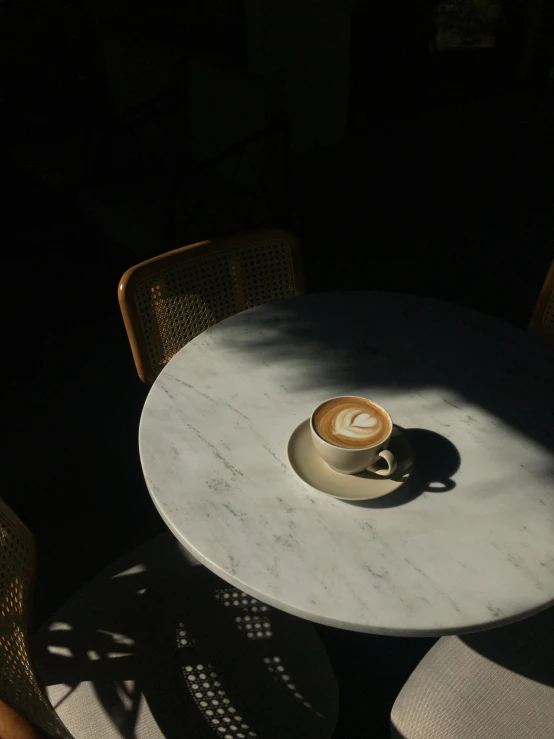 a table and chair with an interesting cup on it
