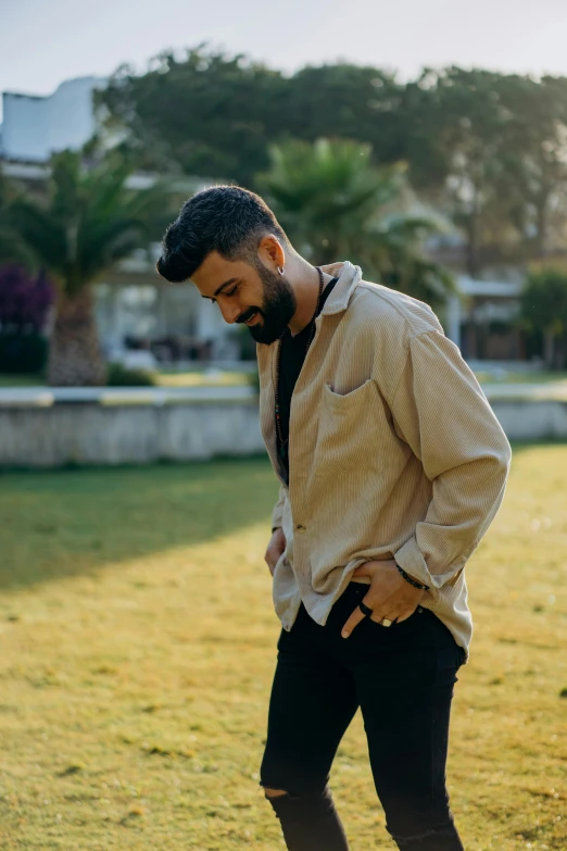 a young man standing alone in the grass