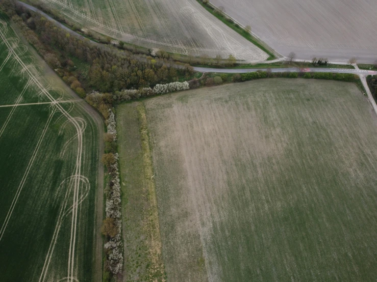 an aerial view of a winding road near some fields