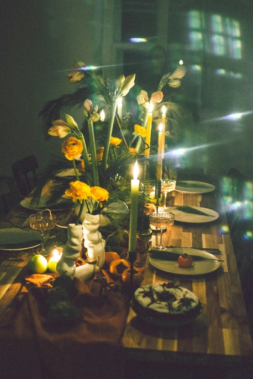 a table with dinner dishes and candles is set