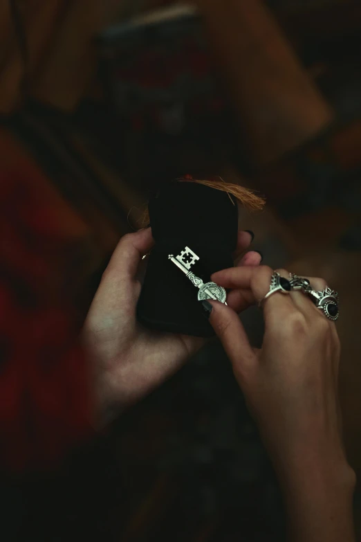 a person holds onto their cell phone as they are both holding two different rings