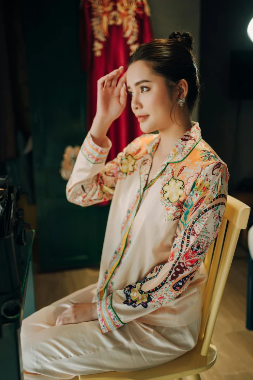 a woman sitting in a chair looking at her watch