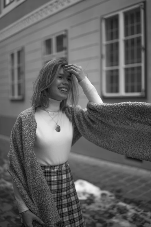 a beautiful woman in a dress smiling next to a building