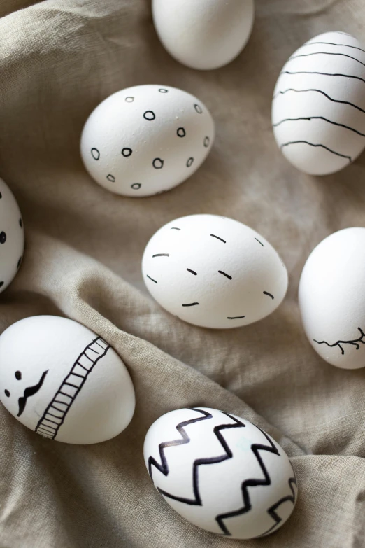 several black and white eggs with drawn faces