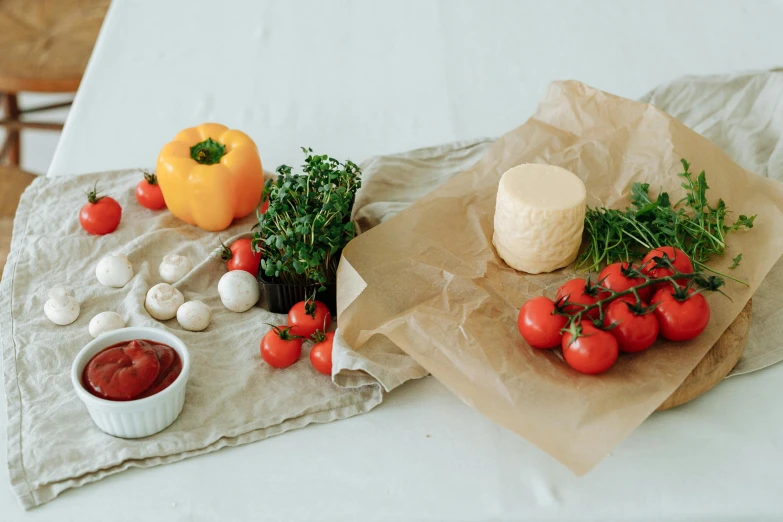 some tomatoes on the table with various other vegetables