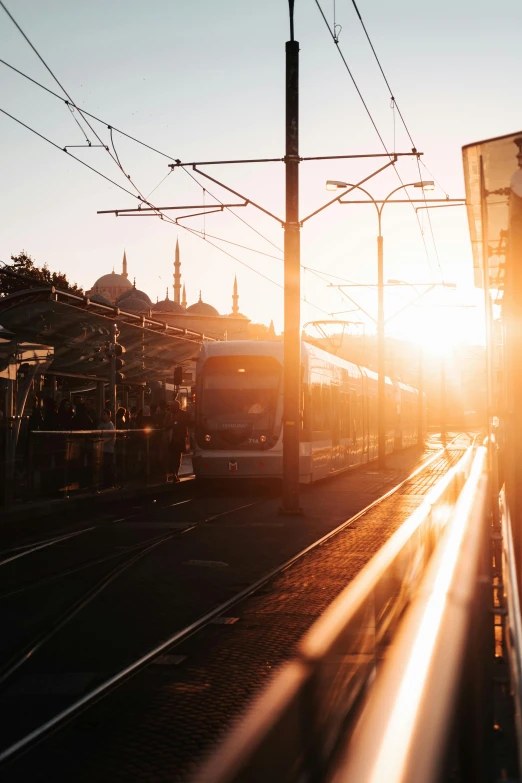 a train passes on the tracks with the sun shining brightly through