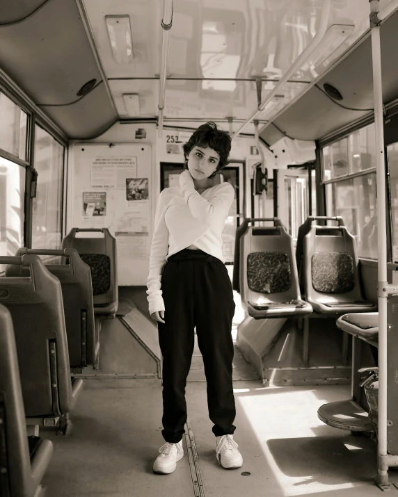 a woman standing next to the back of a bus