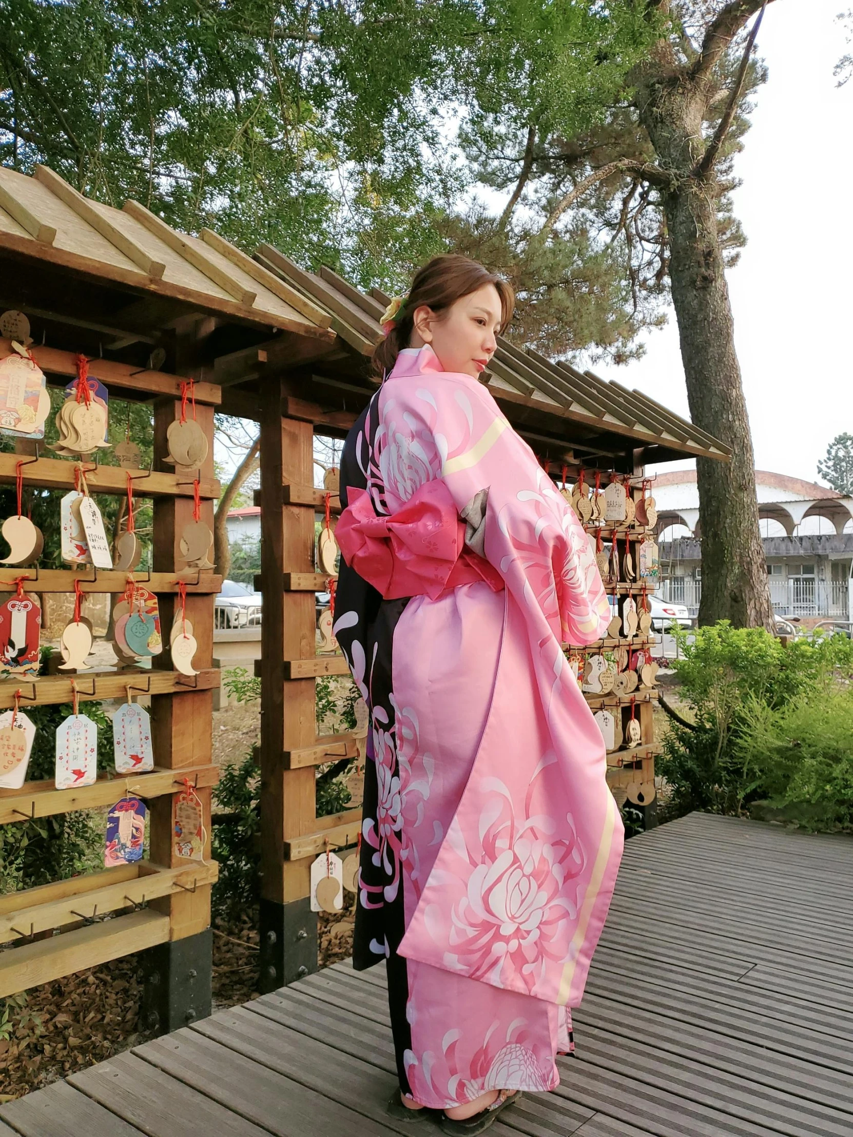 the woman in a pink kimono is walking