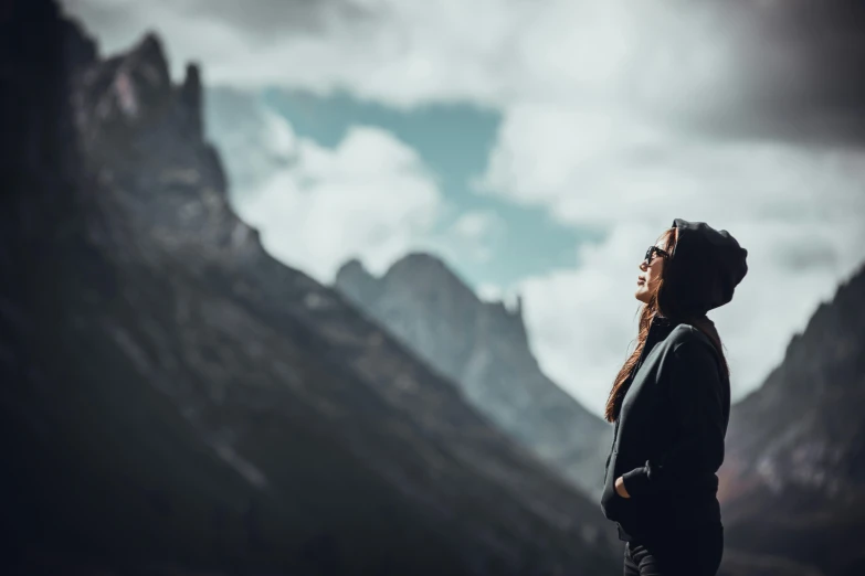 a woman looking up at mountains from below