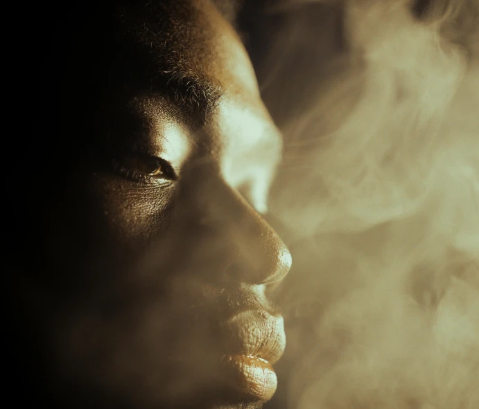 a close up image of a woman's face with steam coming from her mouth