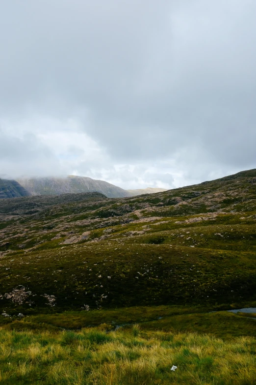 a cloudy mountain with a lake in the foreground