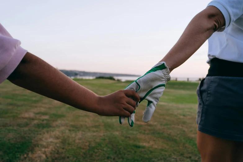 a couple hold hands holding each other in a field