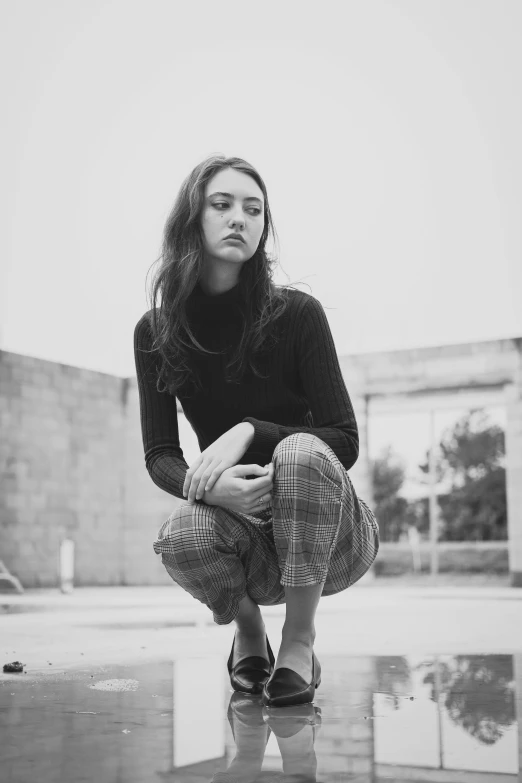 a woman kneeling down looking at her shoes