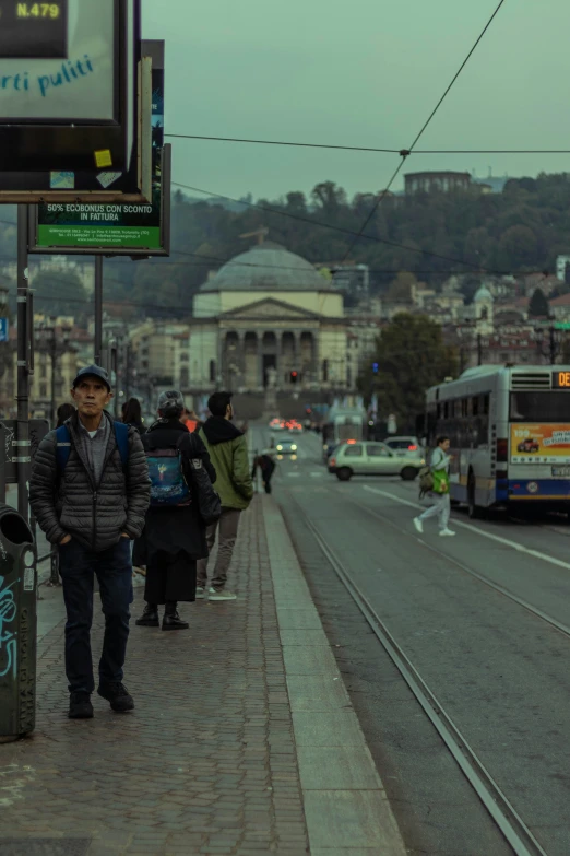 a man stands on the side walk on a city street