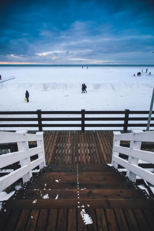 a boardwalk over a large body of water covered in snow