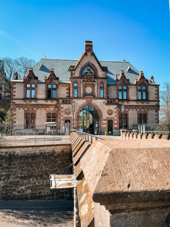 a large brick building with many windows in front of a fence