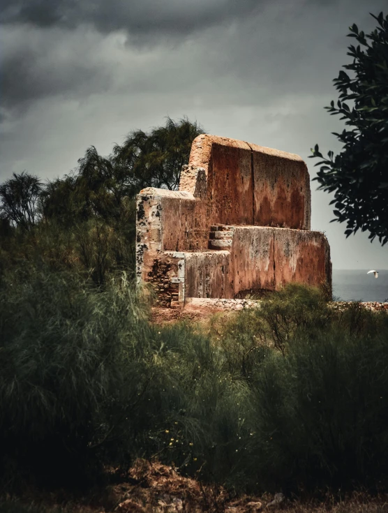 old building sits amongst trees, under a dark sky