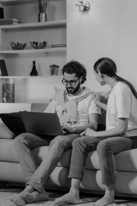 two young men using their laptops in the living room