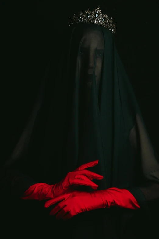 a woman wearing a red dress and gloves with a tiara on her head