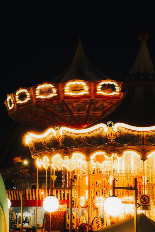 a merry go round with lights on it and other carnival rides