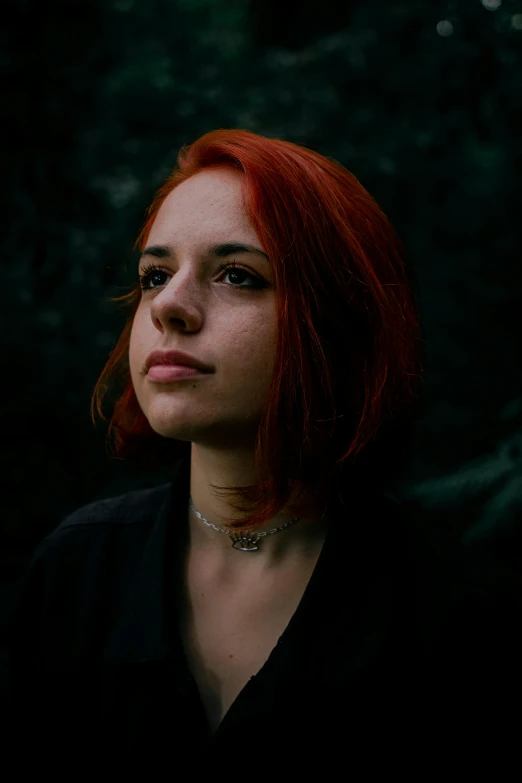 a woman with red hair wearing a black shirt